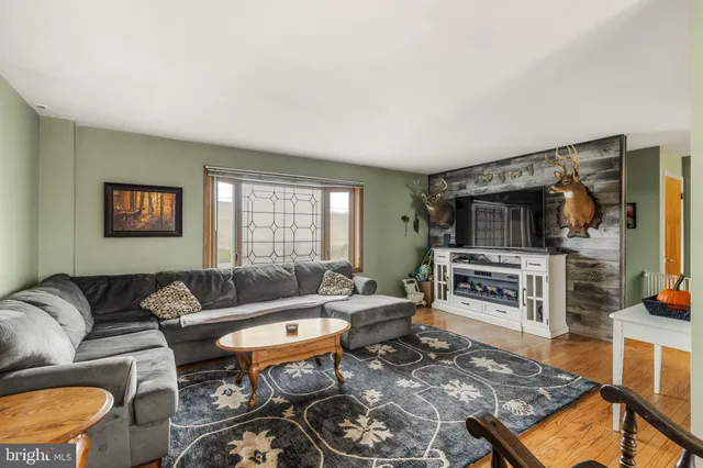 a living room with furniture a flat screen tv and a window