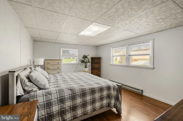 a bedroom with a bed and two windows