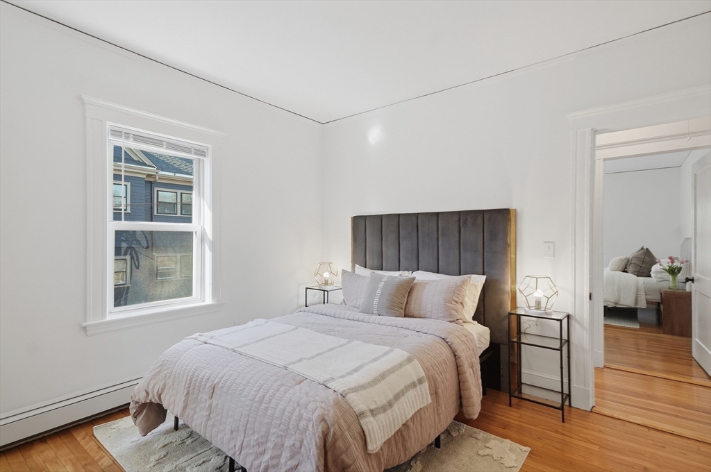 25 Spruce Street, Unit 25 Watertown, MA 02472 - Photo 22 of 39 a bedroom with a bed and wooden floor