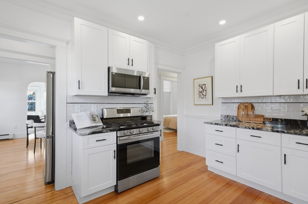 25 Spruce Street, Unit 25 Watertown, MA 02472 - Photo 4 of 39 a kitchen with granite countertop a sink cabinets and stainless steel appliances