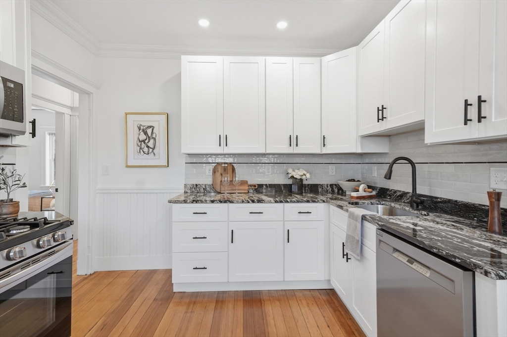 25 Spruce Street, Unit 25 Watertown, MA 02472 - Photo 5 of 39 a kitchen with granite countertop white cabinets and appliances