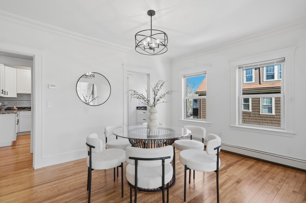 25 Spruce Street, Unit 25 Watertown, MA 02472 - Photo 10 of 39 a dining room with wooden floor a chandelier a wooden table and chairs