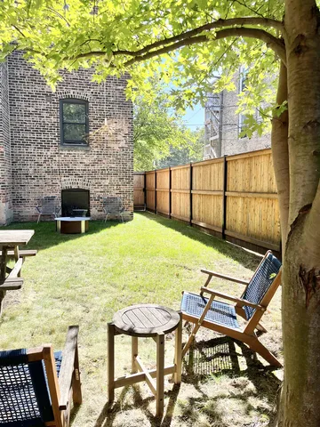 a view of a street with potted plants and brick walls