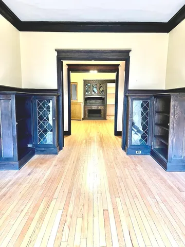 a view of empty room with fireplace and wooden floor