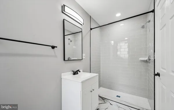 a bathroom with a bathtub shower sink and mirror