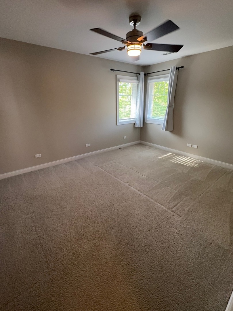 740 Chestnut Street, Unit 2 Deerfield, IL 60015 - Photo 8 of 11 an empty room with windows and ceiling fan