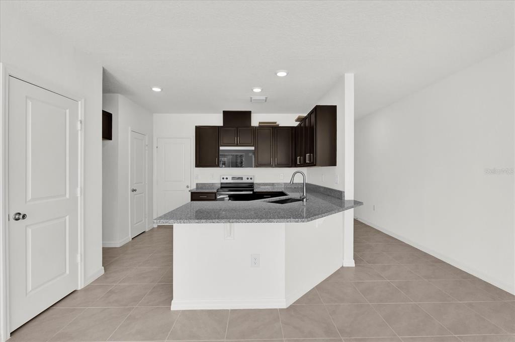 375 Sequoia Drive Lake Wales, FL 33859 - Photo 3 of 16 a kitchen with stainless steel appliances a stove top oven a sink and a refrigerator