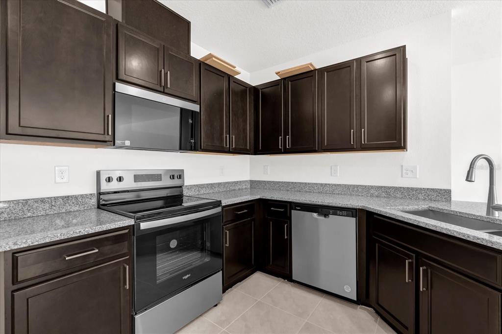 375 Sequoia Drive Lake Wales, FL 33859 - Photo 4 of 16 a kitchen with granite countertop a stove microwave and sink