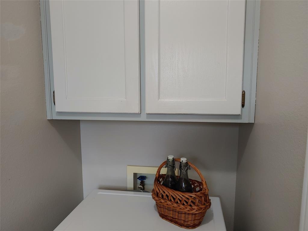 836 Airport Road Reno, TX 75462 - Photo 8 of 30 White upper cabinetry with recessed panel doors and brass-tone hardware