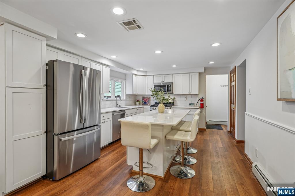 40 Golf Road Bloomfield, NJ 07003 - Photo 16 of 50 a kitchen with stainless steel appliances granite countertop a refrigerator a stove a sink dishwasher and a refrigerator with wooden floor