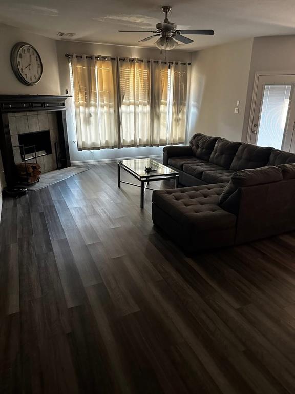 212 Watson Street Red Oak, TX 75154 - Photo 5 of 6 Living room with dark wood-type flooring, a tiled fireplace, and ceiling fan