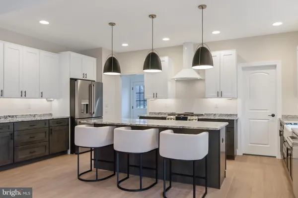 a kitchen with stainless steel appliances granite countertop a stove a sink island and a refrigerator