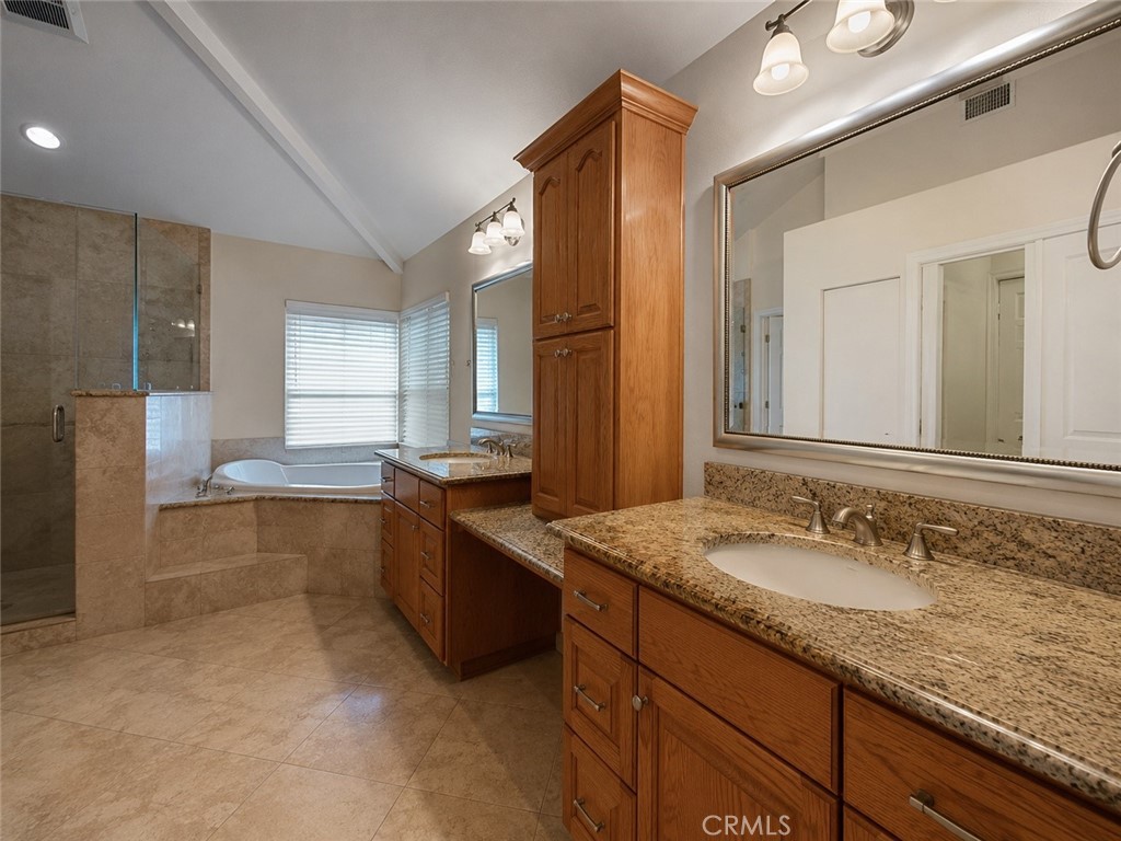 2811 North Roxbury Street Orange, CA 92867 - Photo 6 of 8 a bathroom with a granite countertop bathtub sink and mirror