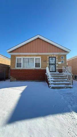 a front view of a house with barbeque and wooden fence