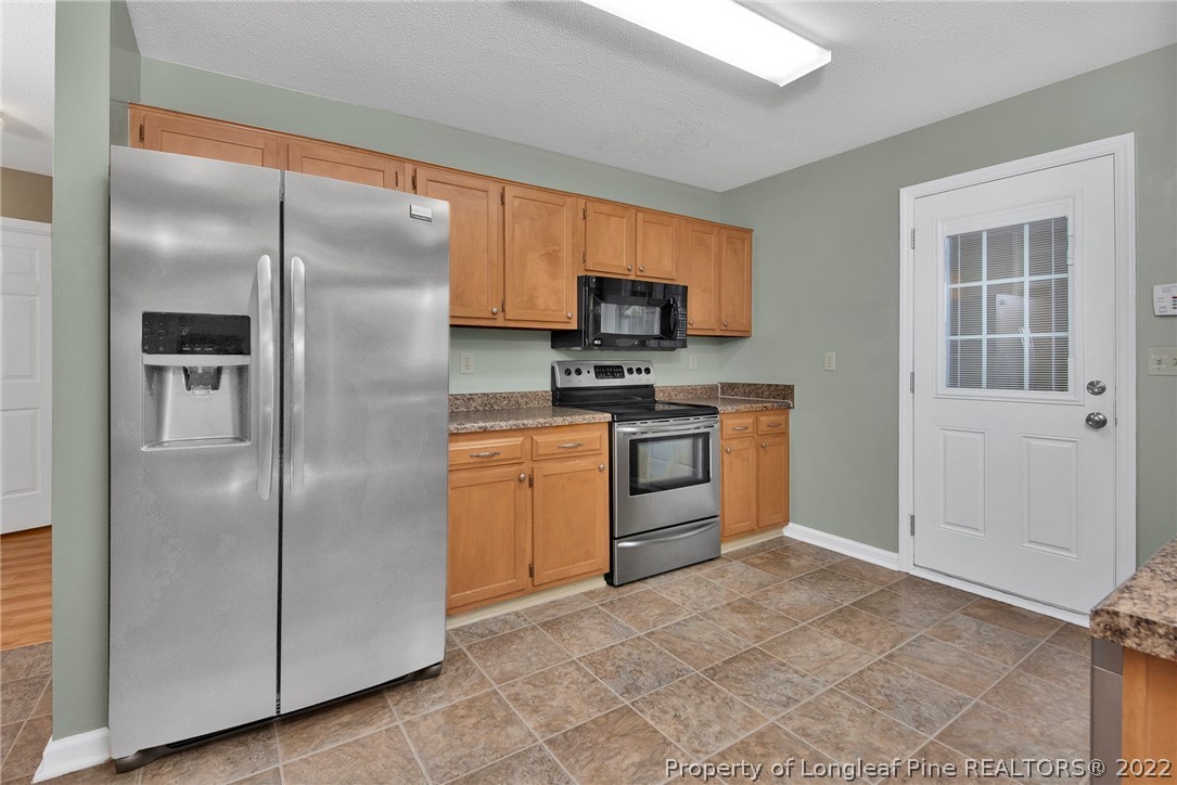 22 Woodridge Lane Cameron, NC 28326 - Photo 27 of 33 a kitchen with a refrigerator a stove top oven a sink and dishwasher