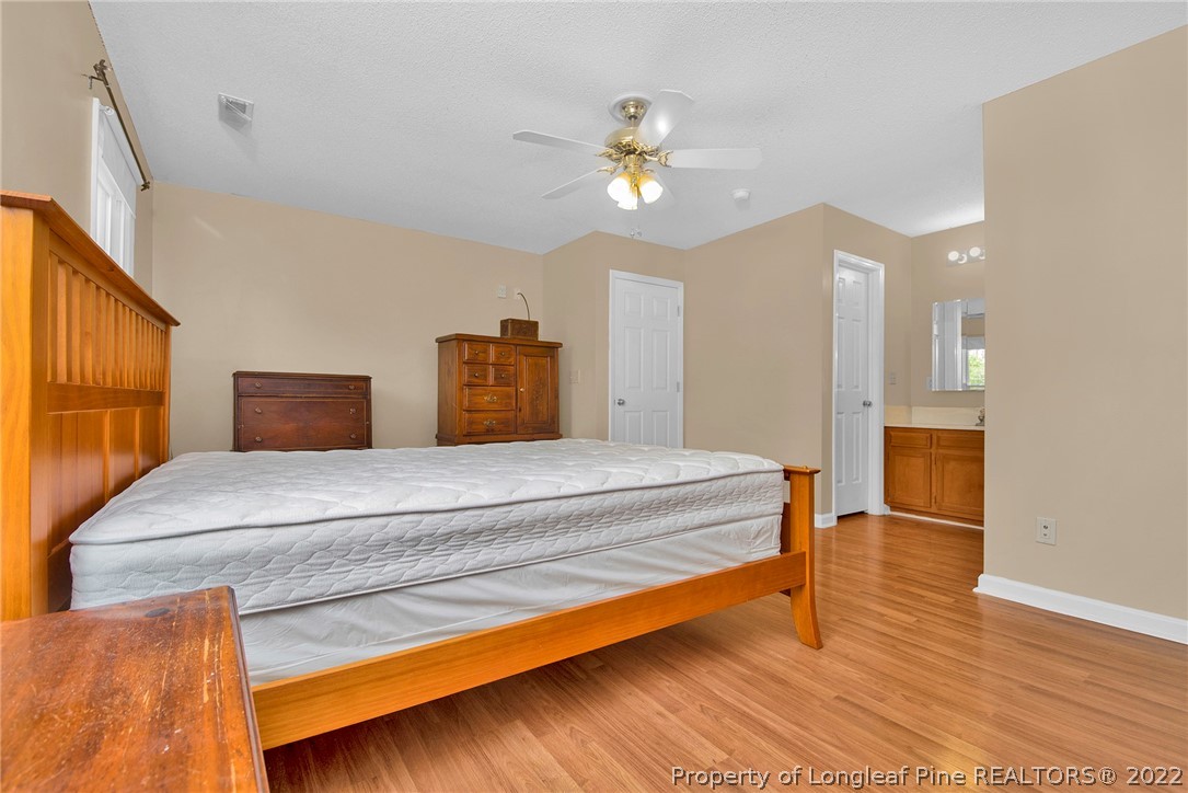 22 Woodridge Lane Cameron, NC 28326 - Photo 6 of 33 a bedroom with a bed and a chandelier