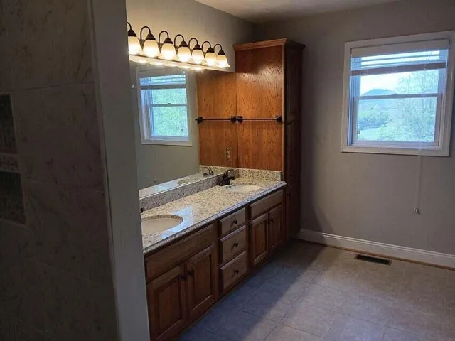 a bathroom with a granite countertop sink and a mirror