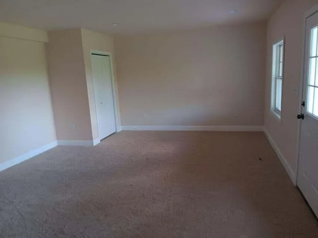 a view of a grassy field with trees in the background