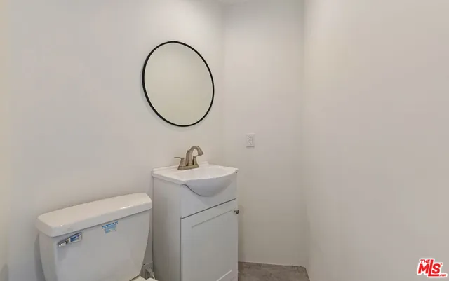 a bathroom with a toilet a sink and a mirror