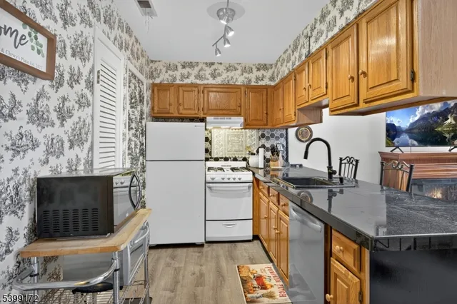a kitchen with stainless steel appliances granite countertop a stove a sink a refrigerator and a microwave