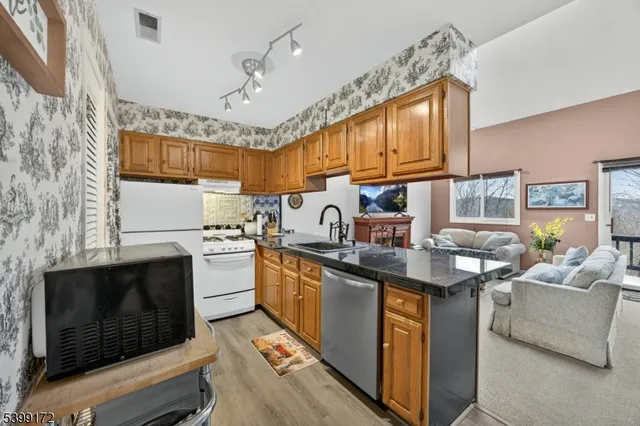 a kitchen with kitchen island granite countertop a sink stove and cabinets