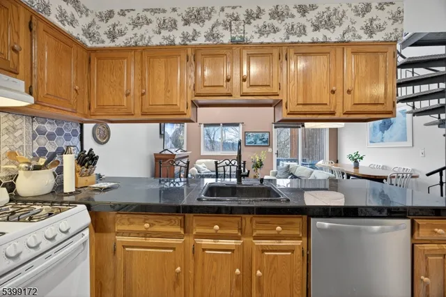a kitchen with stainless steel appliances granite countertop a sink stove and cabinets