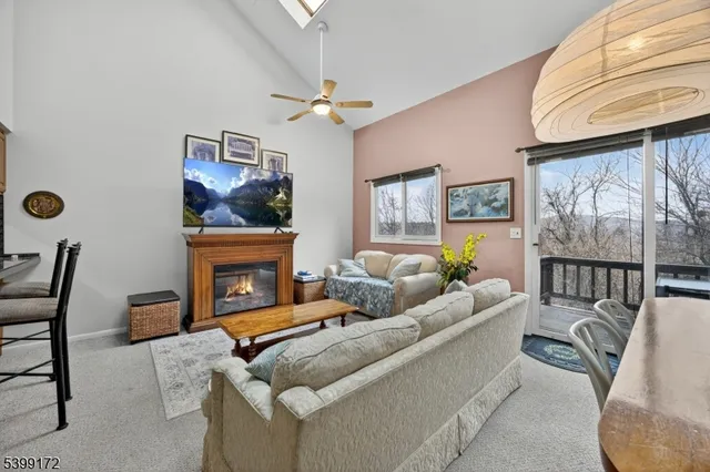 a living room with furniture a fireplace and a large window