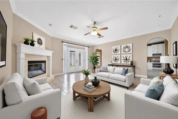 a living room with furniture a rug potted plant and a fireplace