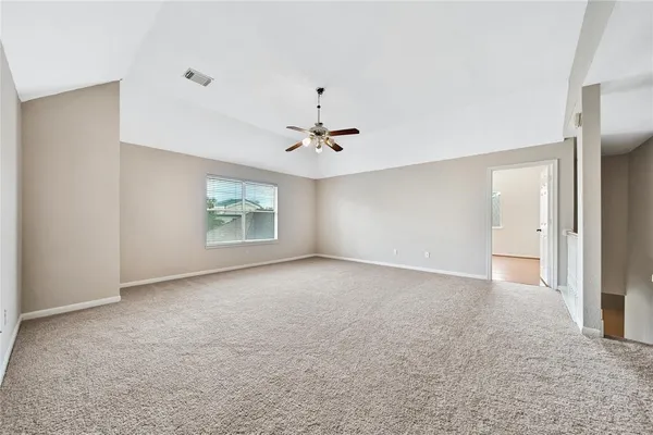 an empty room with wooden floor and chandelier fan