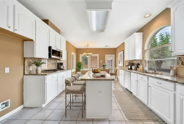 a kitchen with stainless steel appliances kitchen island granite countertop a sink and cabinets