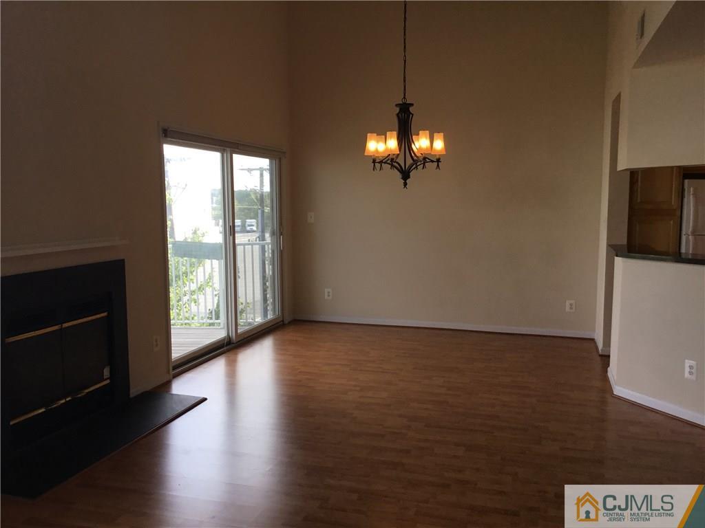 1132 Edpas Road, Unit 1132 New Brunswick, NJ 08901 - Photo 3 of 19 a view of an empty room with wooden floor and a window