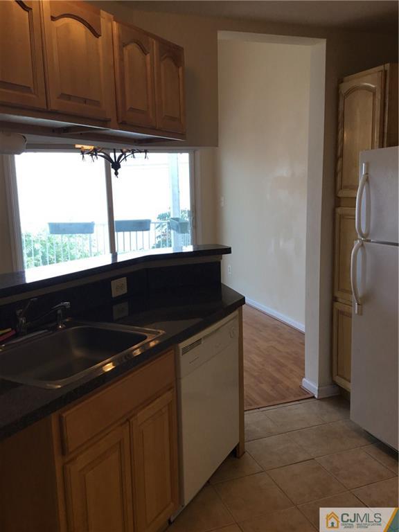 1132 Edpas Road, Unit 1132 New Brunswick, NJ 08901 - Photo 8 of 19 a kitchen with granite countertop a sink and a refrigerator