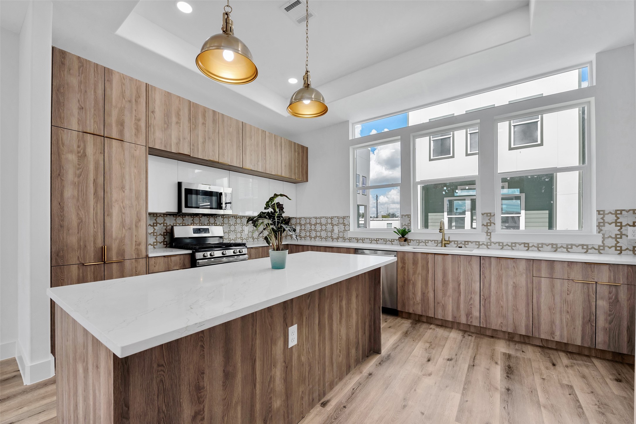1805 Emir Street, Unit G Houston, TX 77009 - Photo 18 of 43 a kitchen with stainless steel appliances a sink a stove a refrigerator cabinets and wooden floor