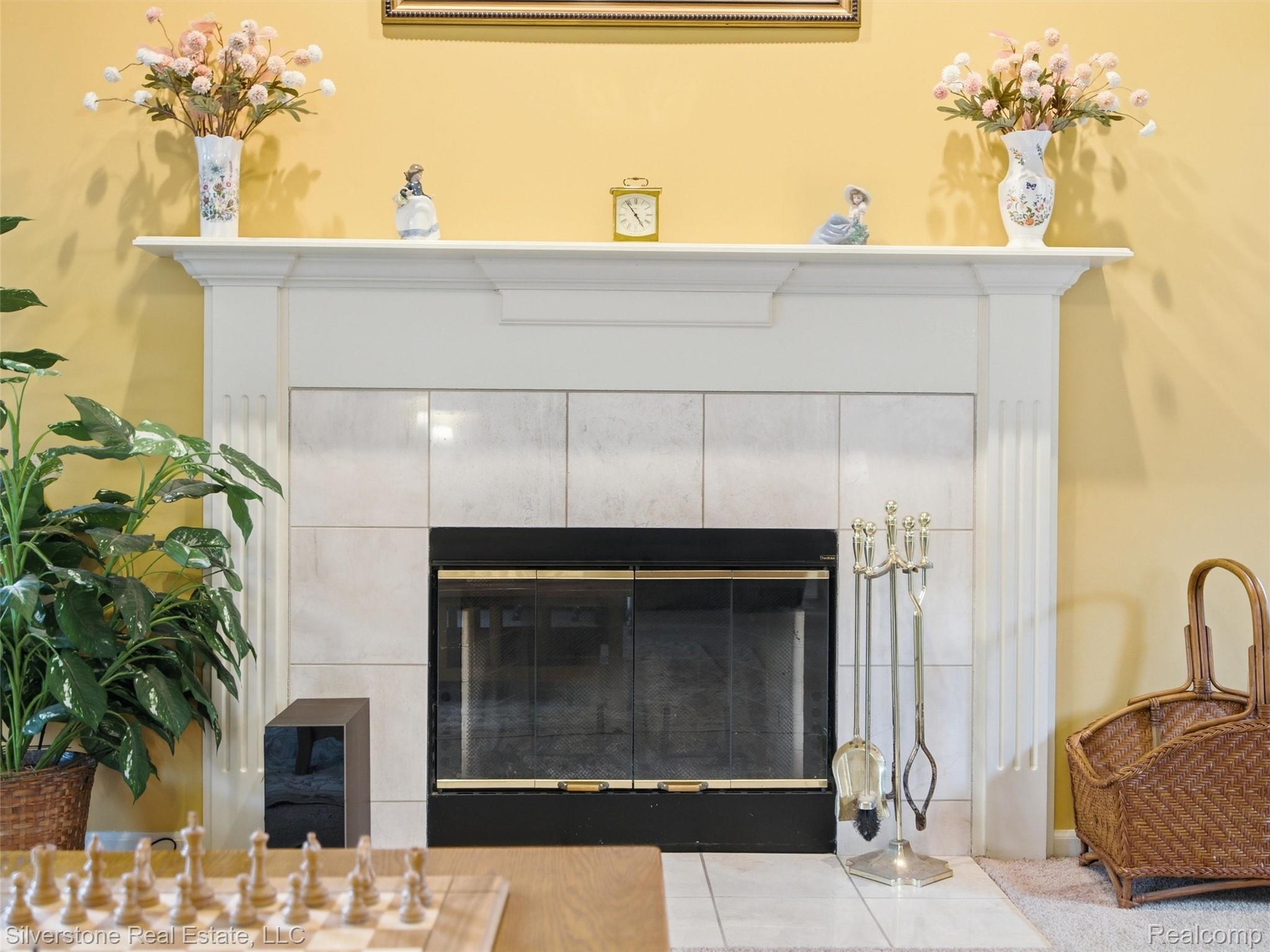 6577 Edith Court Troy, MI 48085 - Photo 16 of 61 Fireplace featuring a white mantel, hearth with light-toned tile surround, and black firebox