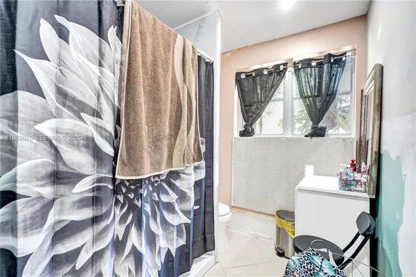 a bathroom with a bathtub a mirror and a shower curtain