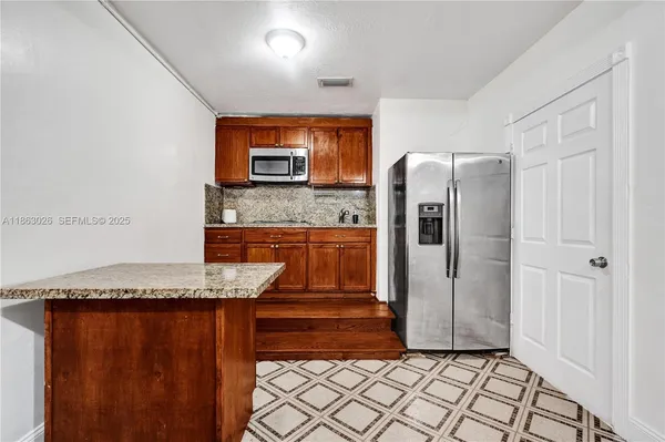 a kitchen with granite countertop a refrigerator and a stove