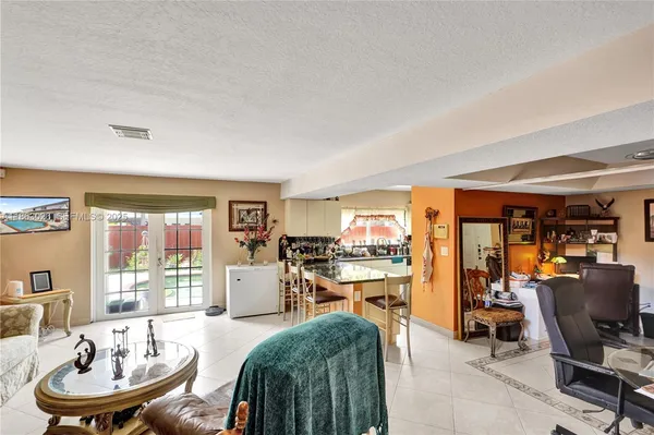 a living room with furniture kitchen view and large windows