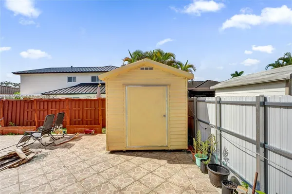 a view of a porch with a door and wooden fence