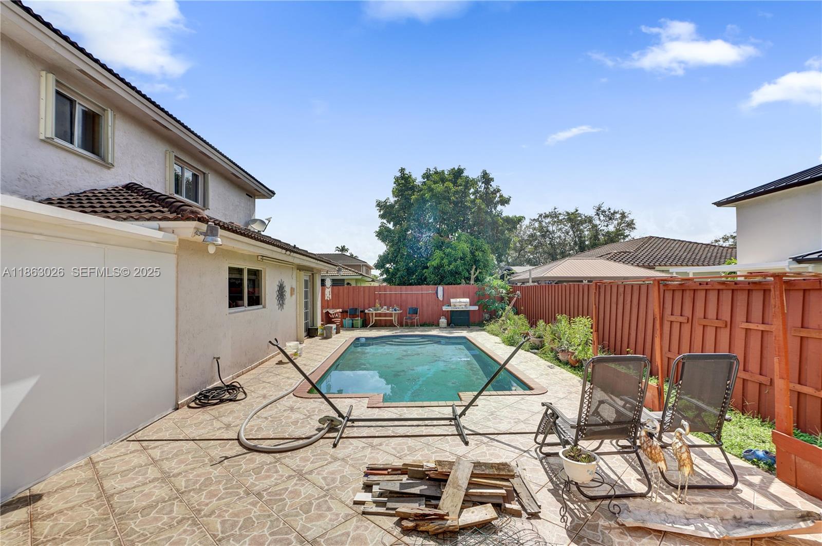 14824 Southwest 180th Street Miami, FL 33187 - Photo 35 of 49 a view of a patio with table and chairs with wooden floor and fence