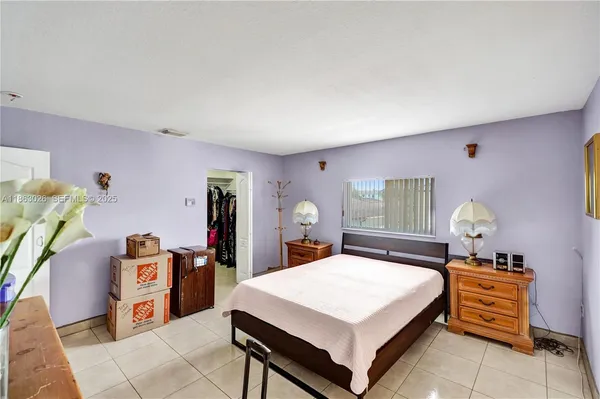 a large bedroom with a bed and a dresser in it