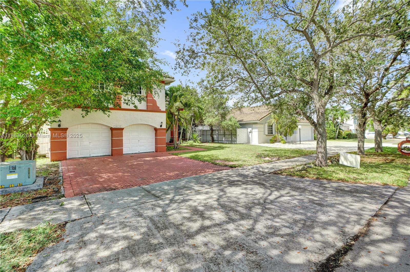 14824 Southwest 180th Street Miami, FL 33187 - Photo 4 of 49 a front view of a house with a yard and garage