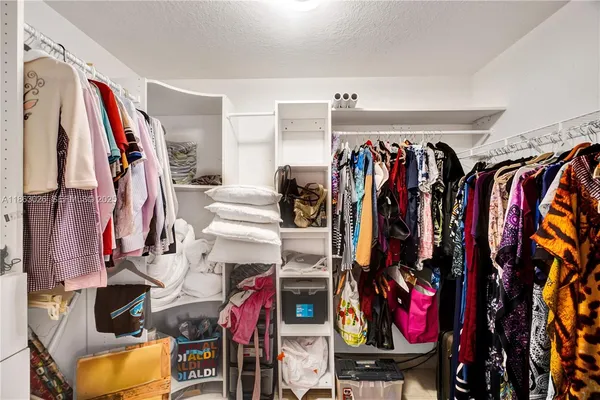 a view of walk in closet with clothes