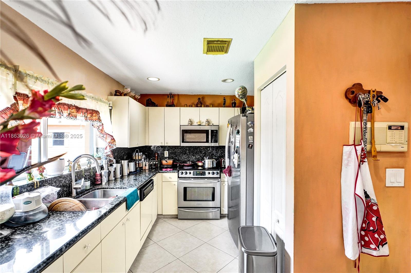 14824 Southwest 180th Street Miami, FL 33187 - Photo 9 of 49 a kitchen with stainless steel appliances granite countertop a sink and cabinets
