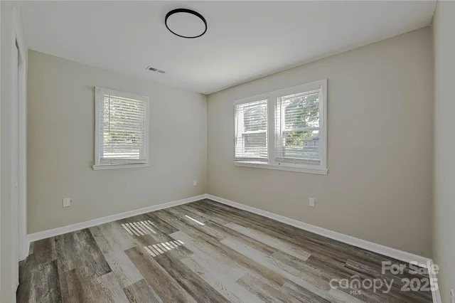 a view of a room with wooden floor and windows