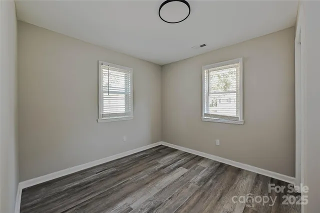 a view of a room with wooden floor and windows