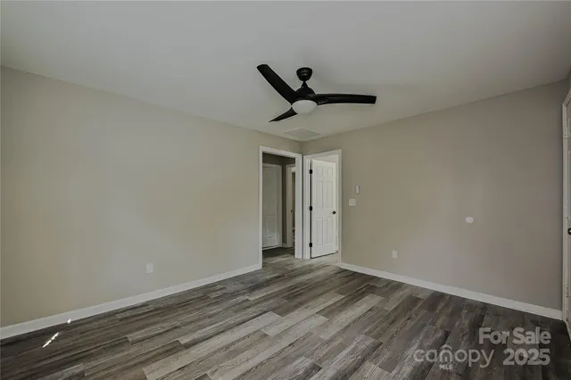 a view of a livingroom with wooden floor and a ceiling fan