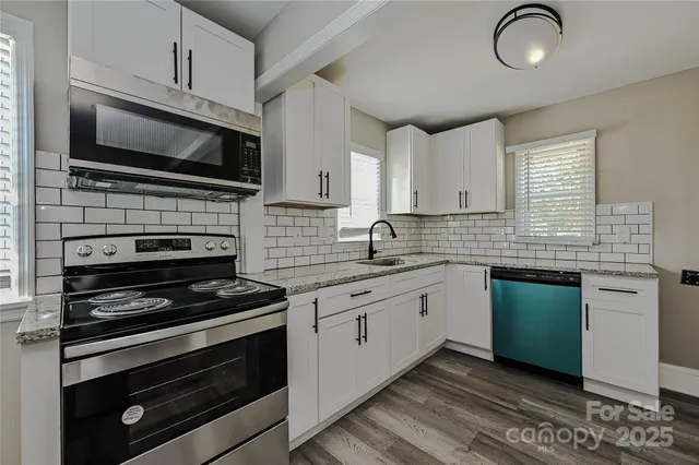a kitchen with stainless steel appliances a stove microwave and sink