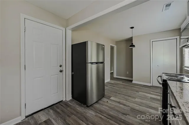 a view of a refrigerator in kitchen and wooden floor
