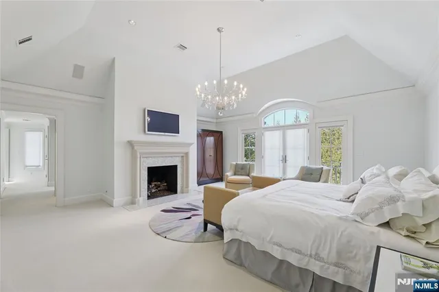 a large white kitchen with stainless steel appliances a sink and cabinets