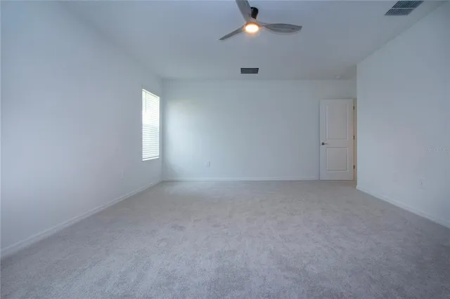 an empty room with an entryway and fan